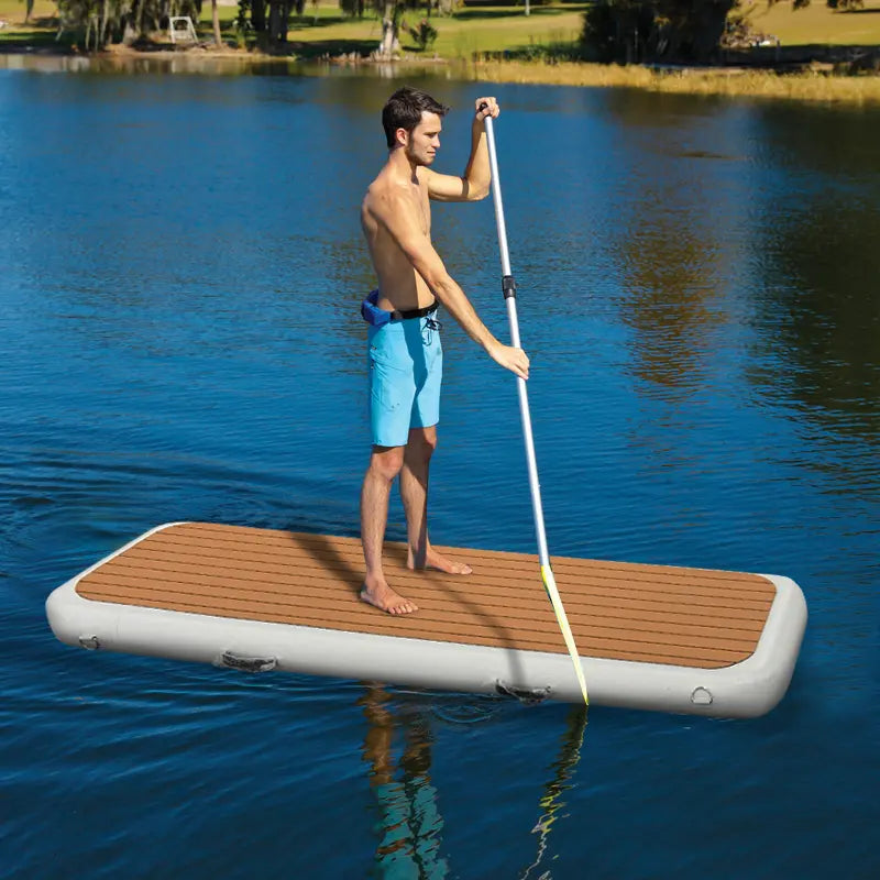 Man standing steadily on an inflatable yacht gangway floating on the lake, showing high buoyancy and stability.